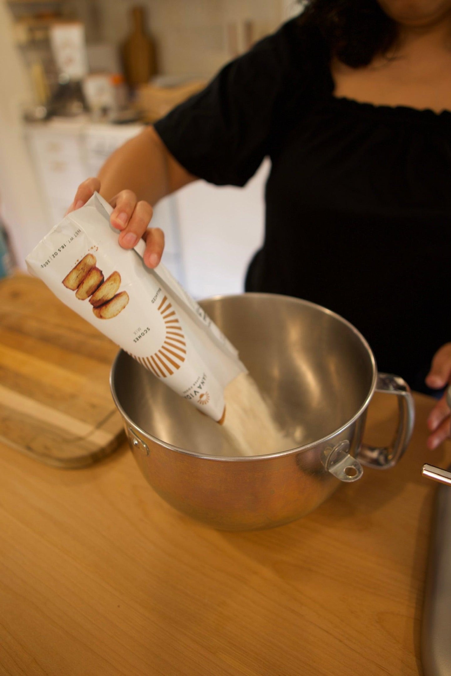 
                  
                    Baker pouring Sana Vidal scone mix into mixing bowl
                  
                