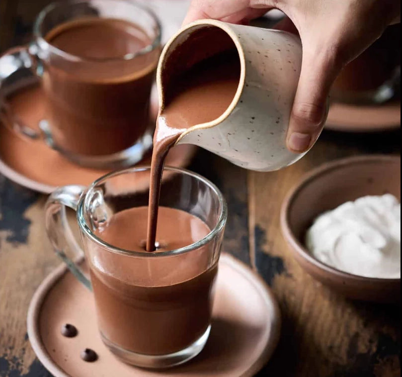 Pouring creamy hot cocoa into a cup